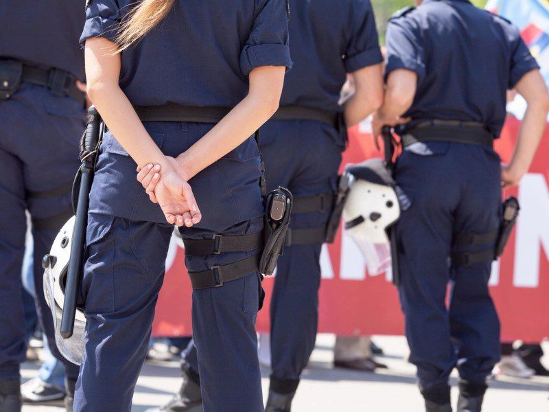 Two police officers in uniform with a dog.